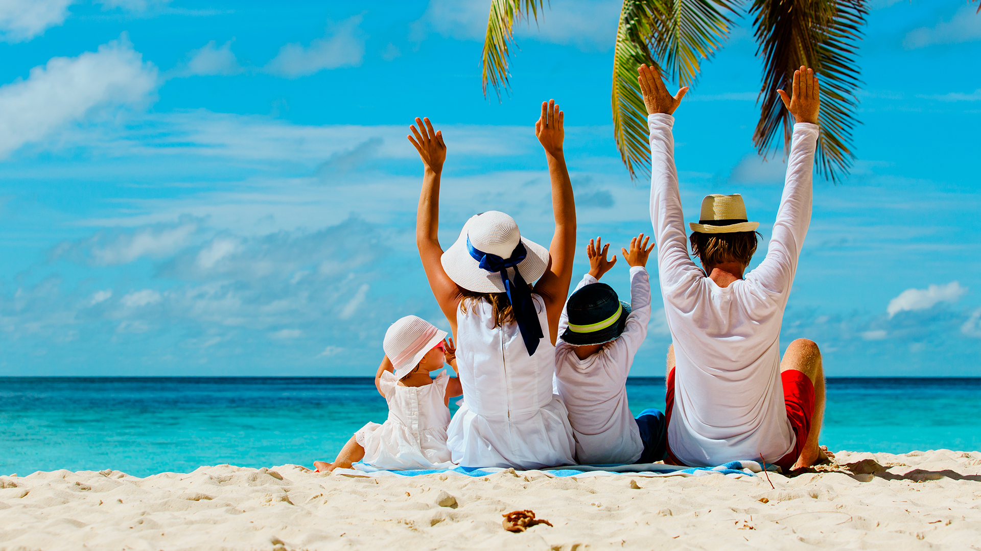 happy family with two kids hands up on beach
